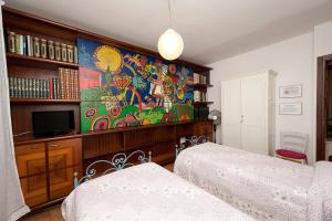 马切拉塔B&B Casa Cettina的一间卧室设有两张床,墙上挂着一幅画
