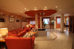 圣多米诺加比阿诺酒店的客厅配有红色的沙发和桌子