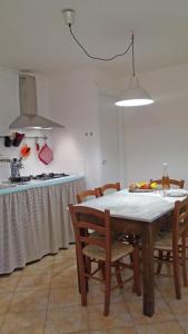韦扎诺利古雷Dolce Casa的厨房配有桌子、椅子和炉灶。