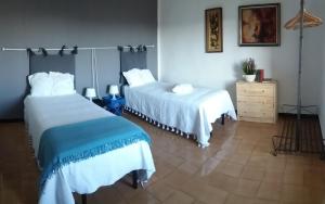 韦扎诺利古雷Dolce Casa的一间卧室配有两张床和梳妆台。