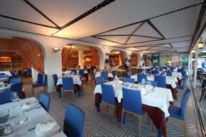 圣多米诺加比阿诺酒店的餐厅设有白色的桌子和蓝色的椅子