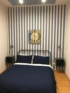 曼弗雷多尼亚La Maison的一间卧室配有一张带条纹墙的床