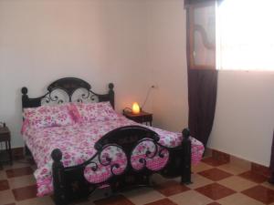 泰赫瑙特Dar Aicha的一间卧室配有一张床和凯特凯特被子