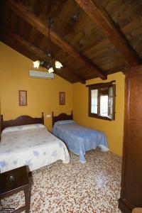埃尔博斯克Casa del Huerto的一间卧室设有两张床和天花板