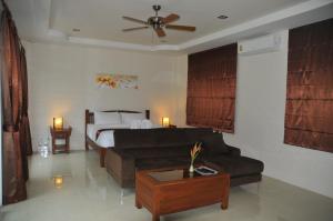 攀牙泰国异域垂钓旅馆的客厅配有床和沙发