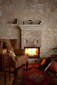 于尔居普卡帕多西亚弗雷斯科窟套房酒店的客厅设有壁炉和沙发。