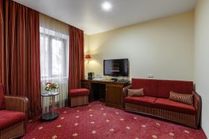 喀山俱乐部酒店科罗纳的酒店客房设有两把椅子和电视