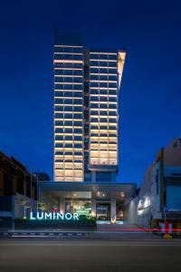 雅加达Luminor Hotel Pecenongan Jakarta By WH的前面有灯号的高楼
