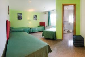 圣达菲阿波罗瑞斯旅舍的一间设有两张床和绿色墙壁的客房