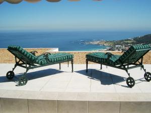 开普敦Camps Bay Villa的两个绿色长椅,坐在屋顶上