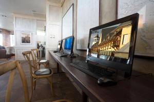 纳塔列斯港科斯淘斯特雷莱丝酒店的一张桌子,上面有电脑显示器,键盘和鼠标
