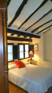 阿尔内迪略Casa Rural Las Pedrolas的一间卧室配有一张带白色床单和窗户的床。