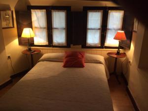 阿尔内迪略Casa Rural Las Pedrolas的一间卧室配有一张床,两台桌子上放着两盏灯