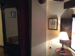 阿尔内迪略Casa Rural Las Pedrolas的坐在镜子旁的桌子上的灯