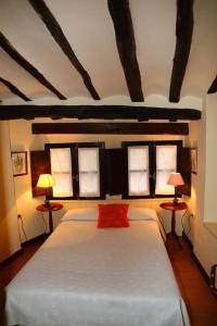 阿尔内迪略Casa Rural Las Pedrolas的一间卧室配有一张带两盏灯的大型白色床。