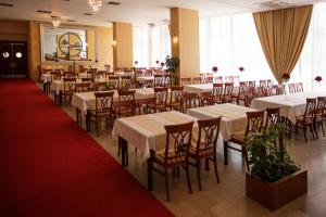 拉克塔希圣巴尼亚卢卡拉克塔奇酒店的餐厅配有白色的桌椅和红地毯