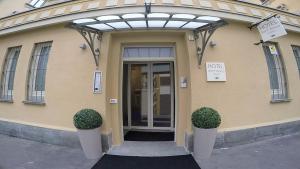 都灵Hotel Sant'Anna的前方有两株植物的建筑物的前门