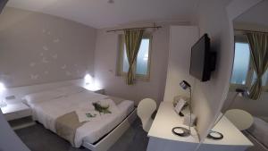 都灵Hotel Sant'Anna的酒店客房设有床、两张桌子和电视。