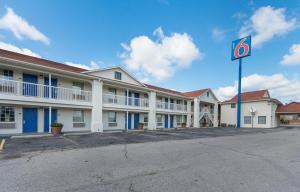 利文斯顿Motel 6-Livingston, TX的停车场没有停车标志的建筑物