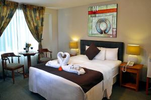 普诺Casona Plaza Hotel Puno的两个天鹅坐在酒店房间的床边