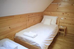 GoreljekChalet Pokljuka的木墙客房内的两张单人床