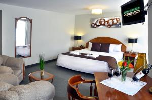 普诺Casona Plaza Hotel Puno的酒店客房带一张床、一张桌子和椅子