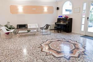 帕尔马诺瓦埃道奇酒店的客厅配有三角钢琴和地毯