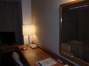Okaya冈谷皇冠山酒店的客房配有带台灯和镜子的书桌