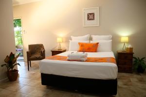 库努纳拉乌南楼住宿加早餐旅馆的一间卧室配有一张带橙色枕头的大床