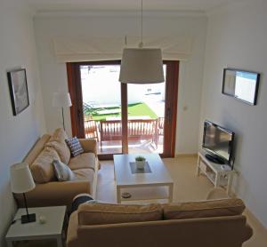 普拉亚布兰卡Apartamento Villa Laura的带沙发、桌子和电视的客厅