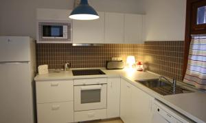 普拉亚布兰卡Apartamento Villa Laura的厨房配有白色橱柜、水槽和冰箱。