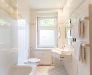莱比锡莱比锡马克格拉弗酒店的一间带卫生间、水槽和窗户的浴室