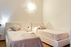 维罗纳Maison de Amelie的卧室配有两张床,墙上有灯