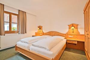 格罗萨尔Appartementhaus Alpenpark的一间卧室设有一张木床和一个窗户。
