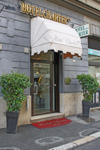 罗马夏特酒店的建筑前有两株盆栽植物的酒店入口