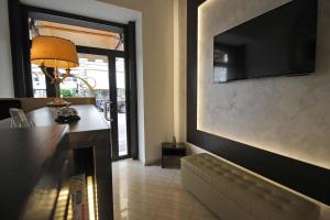 罗马夏特酒店的客厅配有沙发和墙上的电视