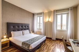 科莫艾尔伯格菲兰其酒店的一间卧室设有一张大床和两个窗户。