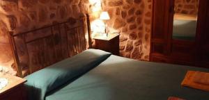 拉里奥哈Cabañas Altos del Velazco的一间卧室配有一张带蓝色棉被的床
