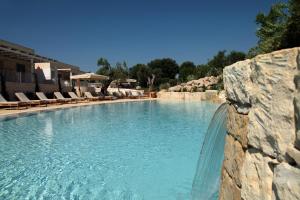 奥特朗托Borgo de li Santi的度假村内的大型游泳池,配有椅子