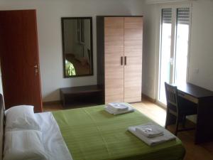 米兰欧洲住宿加早餐酒店的一间卧室配有一张带书桌和镜子的床