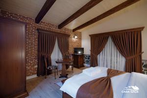 戈里察Casa Gaçe Hotel的一间卧室配有一张床、一张书桌和一台电视