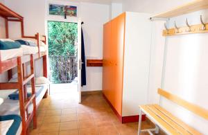 伊诺赫多Hostel albergue Paradiso的一间设有双层床的客房和一扇带窗户的门