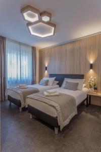 布列瑟农旅游者酒店的一间卧室配有两张床和吊灯。