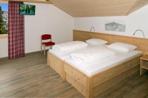 埃尔姆比斯科法尔普宾馆的一间卧室配有木床和红色椅子
