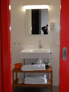VillafrancaHospedería de Alesves的浴室配有盥洗盆、镜子和毛巾