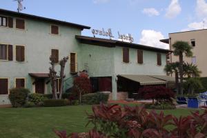 西尔米奥奈博莱罗酒店的一座白色的大建筑,前面有棕榈树