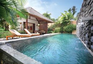 圣吉吉Qunci Villas Resort的一个带两把椅子的游泳池以及一座房子