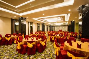 巴淡岛中心巴淡岛中心萨希德会议酒店的宴会厅配有红色和黄色的桌椅