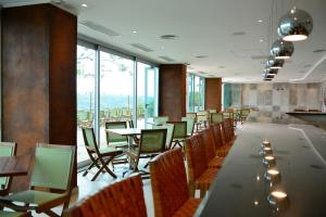 伊瓜苏港Hotel Guaminí Misión的用餐室配有桌椅和大窗户