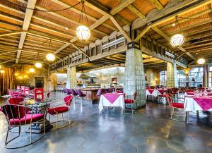 蓬费拉达Hotel Temple Ponferrada的大楼内一家餐厅,配有红色的桌椅